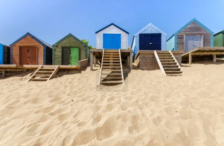 Téléchargez les photos : Une ligne de cabanes de plage sur une plage de sable - en image libre de droit