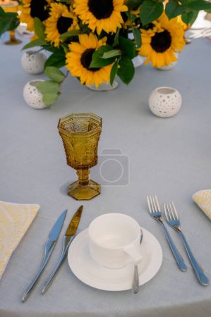 Téléchargez les photos : Un plan vertical de décorations de tournesol, couverts, et une tasse de thé sur une table - en image libre de droit