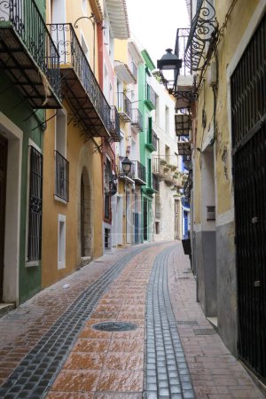 Foto de Un plano vertical de una calle estrecha con edificios coloridos en Alicante, España - Imagen libre de derechos