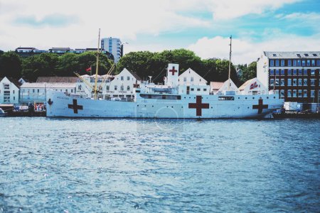 Téléchargez les photos : Le navire blanc flottant avec des croix rouges sur la baie de Trondheim, Norvège - en image libre de droit