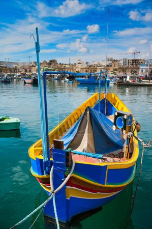 View of Traditional fishing boats Luzzu in the Ancient Mediterranean Village of fishermen