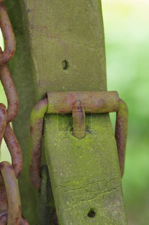 Téléchargez les photos : Une chaîne en métal vert rouillé sur un poteau de fer, plan vertical - en image libre de droit