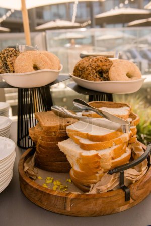 Téléchargez les photos : Un plan vertical d'un plateau de pain tranché et de bagels lors d'un dîner buffet - en image libre de droit