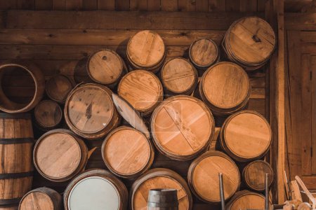 Photo for A large heap of wooden wine barrels in a rustic barn - Royalty Free Image