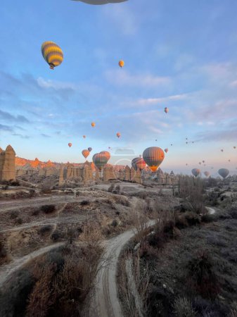 Téléchargez les photos : Un plan vertical de montgolfières survolant Kapadokya Nevsehir au coucher du soleil, Turquie - en image libre de droit