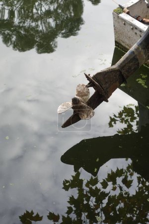 Photo for A vertical shot of an old rustic ship propeller in a lake - Royalty Free Image