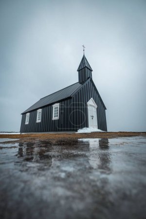 Téléchargez les photos : Un plan vertical de l'église Budakirkja et son reflet dans l'eau en face à Budir, Islande - en image libre de droit