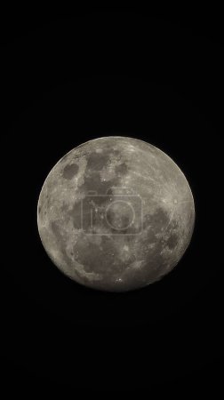 Foto de Un plano vertical de la luna llena aislado sobre un fondo negro. - Imagen libre de derechos