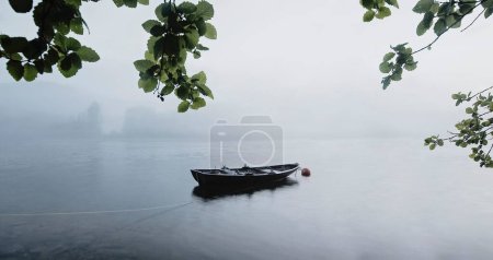 Téléchargez les photos : Un petit bateau seul sur la rivière Nidelva avec du brouillard en arrière-plan - en image libre de droit