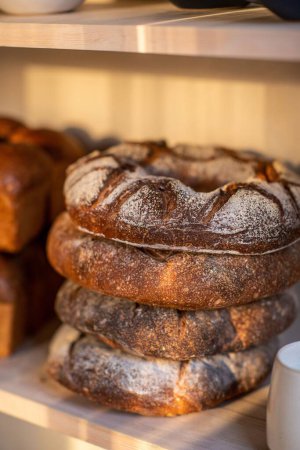 Photo for A vertical shot of the fresh assortments of bread on the shelf in the bakery - Royalty Free Image