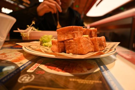 Photo for A closeup shot of French toast cubes and a piece of lettuce against the person eating a dish - Royalty Free Image