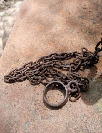 Foto de Un primer plano de cadenas oxidadas sobre una piedra - Imagen libre de derechos
