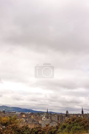 Photo for A verical shot of the cityscape of Edinburgh in autumn and the clouded sky - Royalty Free Image