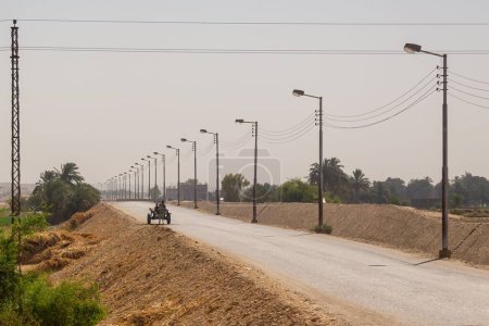 Téléchargez les photos : Vue d'une charrette d'ânes sur une route longue et vide à Louxor, Égypte - en image libre de droit