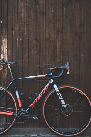 Photo for A vertical shot of a specialized Crux bicycle leaning on a wooden wall - Royalty Free Image