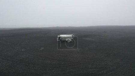 Téléchargez les photos : Vue aérienne d'une vieille épave d'avion au milieu d'un champ par temps brumeux - en image libre de droit