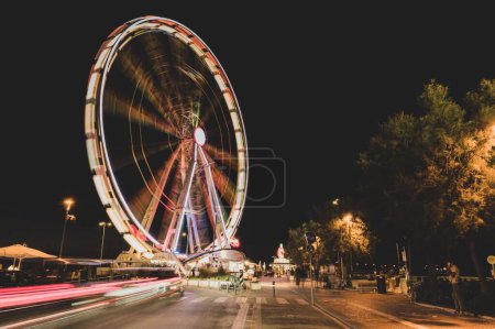 Foto de Un largo disparo de exposición de una rueda de la fortuna en la noche con luces de colores en Rímini, Italia - Imagen libre de derechos