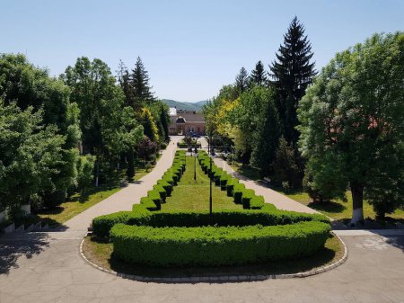 Foto de Un camino con arbustos decorativos y lámparas conduce a una casa de piedra en un hermoso parque en un día de verano - Imagen libre de derechos
