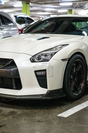 Photo for A vertical shot of a white Nissan GT-R sportscar in a parking lot - Royalty Free Image
