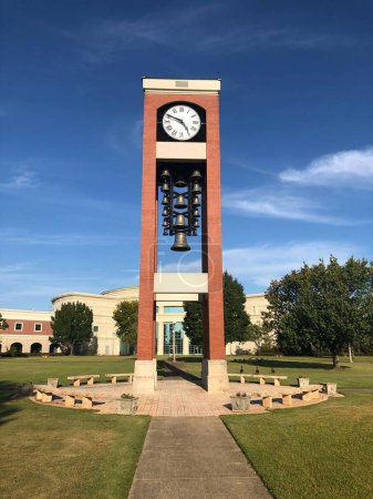 Photo for A vertical shot of the Shelton State Community College yard with a stone watch sculpture with bells in Old Greensboro Rd, Tuscaloosa, USA - Royalty Free Image