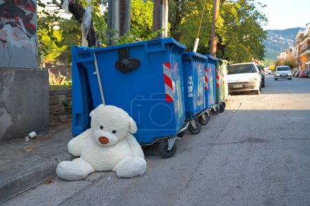 Foto de Juguete de peluche de los niños en la basura. oso de peluche dejado en un cubo de basura. - Imagen libre de derechos