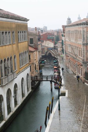 Téléchargez les photos : Vue verticale d'un canal entouré de vieux bâtiments par une journée brumeuse à Venise, en Italie - en image libre de droit