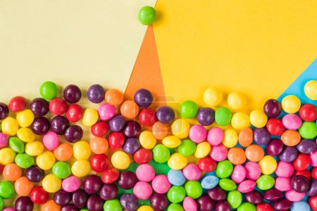 Photo for An overhead shot of sweet candies on the colorful surface - Royalty Free Image