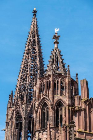 Foto de Un plano vertical de la catedral Freiburger Munster contra un cielo azul. - Imagen libre de derechos