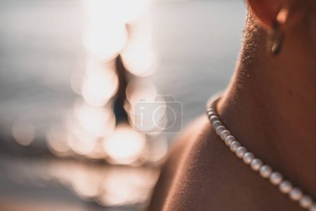Photo for A close-up shot of pearls on a female neck with a bokeh background - Royalty Free Image