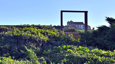Téléchargez les photos : Un beau cliché à travers une porte en bois dans un vieux château entouré de verdure sous le ciel bleu - en image libre de droit