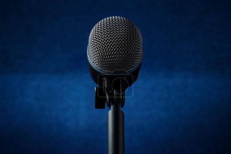 Téléchargez les photos : Plan rapproché d'un microphone métallique avec un poteau isolé sur un fond bleu - en image libre de droit