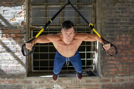 Téléchargez les photos : Un homme caucasien musclé faisant des exercices dans la salle de gym - en image libre de droit