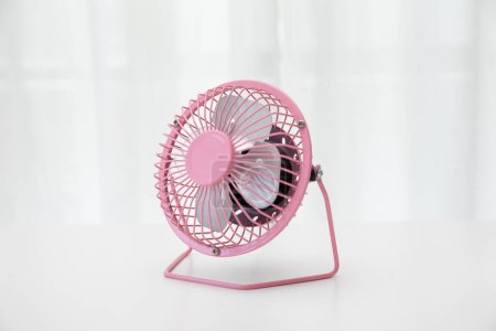 Photo for A close-up of a pink small desk USB 4 blades cooling fan on a white background - Royalty Free Image