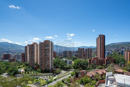 Foto de Una vista aérea de la ciudad de Medellín con edificios altos y naturaleza verde en un día soleado brillante - Imagen libre de derechos
