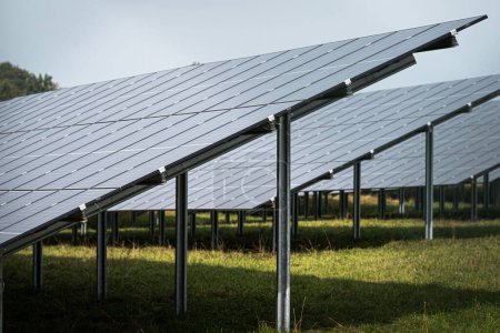 Foto de Los paneles del sistema solar en la gran central fotovoltaica en el campo verde - Imagen libre de derechos