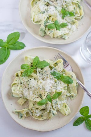 Photo for A vertical shot of white sauce pasta with parmesan and vegetables - Royalty Free Image