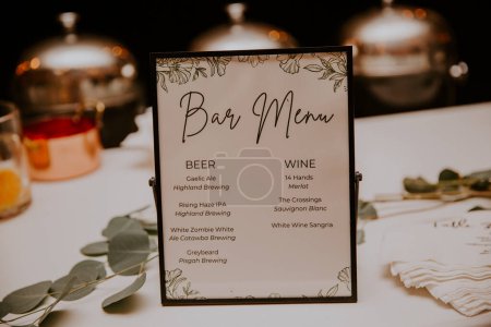 Foto de Un primer plano de un menú de bar en la mesa con bebidas en ella en una ceremonia de boda - Imagen libre de derechos