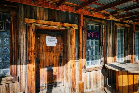Téléchargez les photos : Une porte d'entrée en bois avec une note dessus sous la lumière du soleil - en image libre de droit
