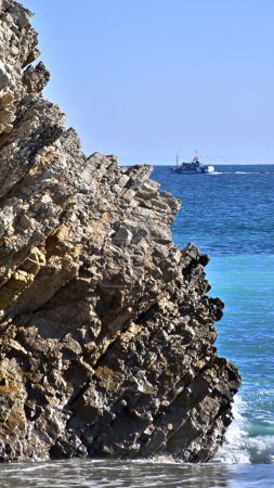 Téléchargez les photos : Belle vue sur la plage de Praia da Mijona et la mer bleue entourée de collines rocheuses sous un ciel clair au Portugal - en image libre de droit