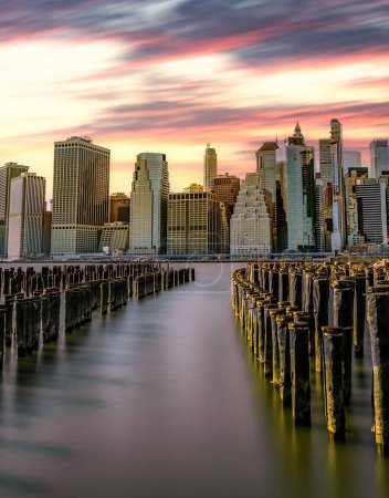 Photo for A vertical long exposure shot of a sunset over the New York skyline from Pier 1 Brooklyn. - Royalty Free Image