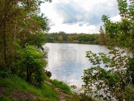 Photo for A beautiful shot of a lake surrounded by trees under a cloudy sky - Royalty Free Image