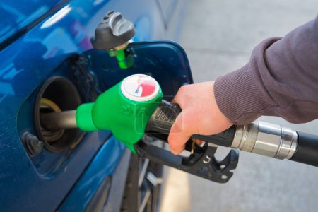 Foto de Bombeo de gasolina en el coche en una gasolinera. Llenar el automóvil con el combustible en la gasolinera. Bomba de gasolinera - Imagen libre de derechos