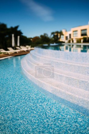 Téléchargez les photos : Le plan vertical d'une piscine extérieure vide dans une zone de villégiature par une journée ensoleillée - en image libre de droit