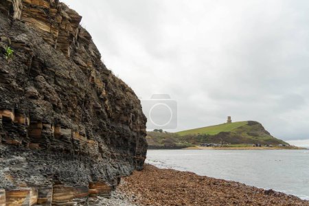 Photo for The coastal view at Kimmeridge Bay, Dorset, UK, showing the layers of oil shale, mudstone and limestone in the cliff. - Royalty Free Image