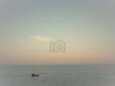 Téléchargez les photos : Un beau plan d'un bateau seul dans l'océan au coucher du soleil - en image libre de droit