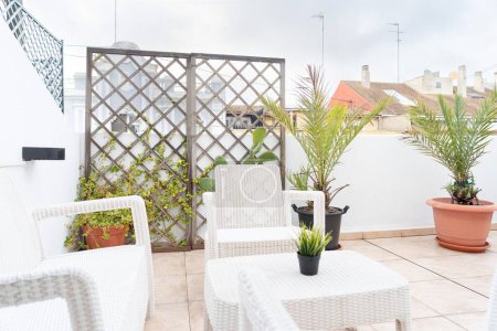 Foto de Una terraza ático amueblado con macetas, mesa y sillas - Imagen libre de derechos