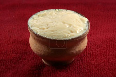 Photo for A bowl of Bengali sweet curd isolated on red background - Royalty Free Image