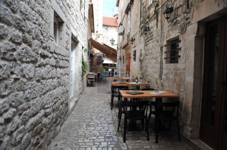 Téléchargez les photos : Un petit restaurant dans une ruelle étroite isolée à Trogir, Croatie - en image libre de droit