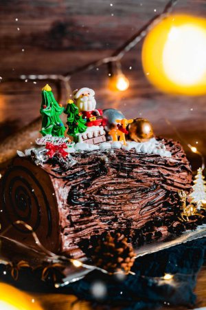 Foto de Una toma vertical de un pastel de Navidad de chocolate decorativo con glaseado marrón y coberturas navideñas - Imagen libre de derechos