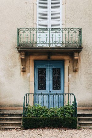 Foto de Un plano vertical de un edificio antiguo, puerta de entrada azul y pequeño balcón sobre él - Imagen libre de derechos